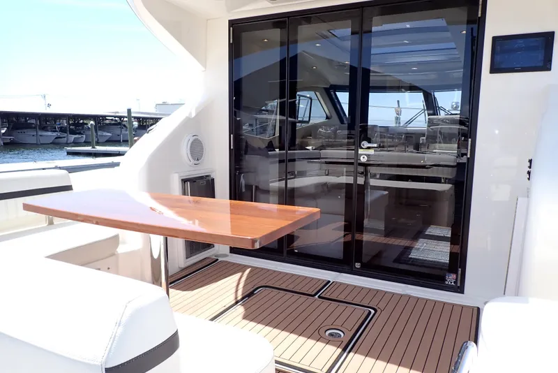 Slide: The Image of 2019 Carver C37 Coupe yacht interior with wooden table and glass doors. - 21