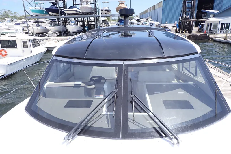 Slide: The Image of 2019 Carver C37 Coupe boat docked at marina, showcasing sleek design and windshield wipers. - 40