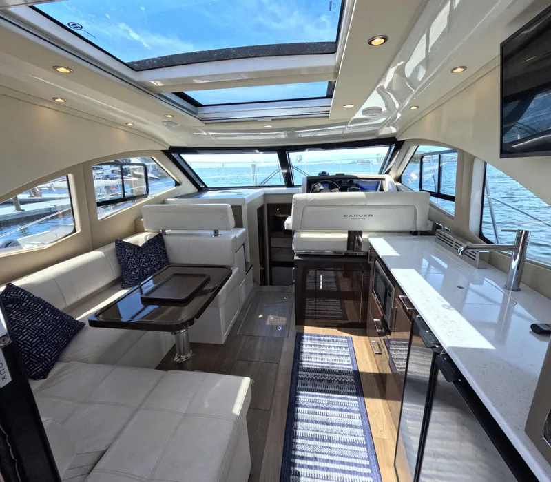 Slide: The Image of Luxurious interior of 2019 Carver C37 Coupe yacht with modern furnishings and panoramic windows. - 6