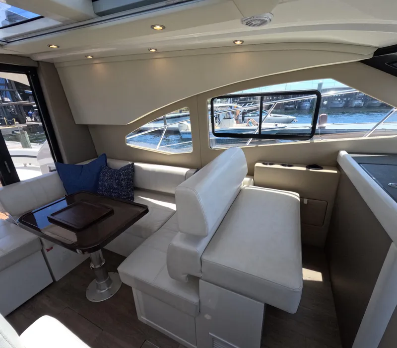 Slide: The Image of Interior of 2019 Carver C37 Coupe yacht with plush seating and waterfront view. - 8