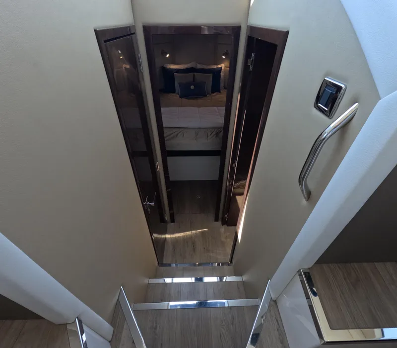 Slide: The Image of Interior of 2019 Carver C37 Coupe, featuring stairs leading to a cozy bedroom. - 12