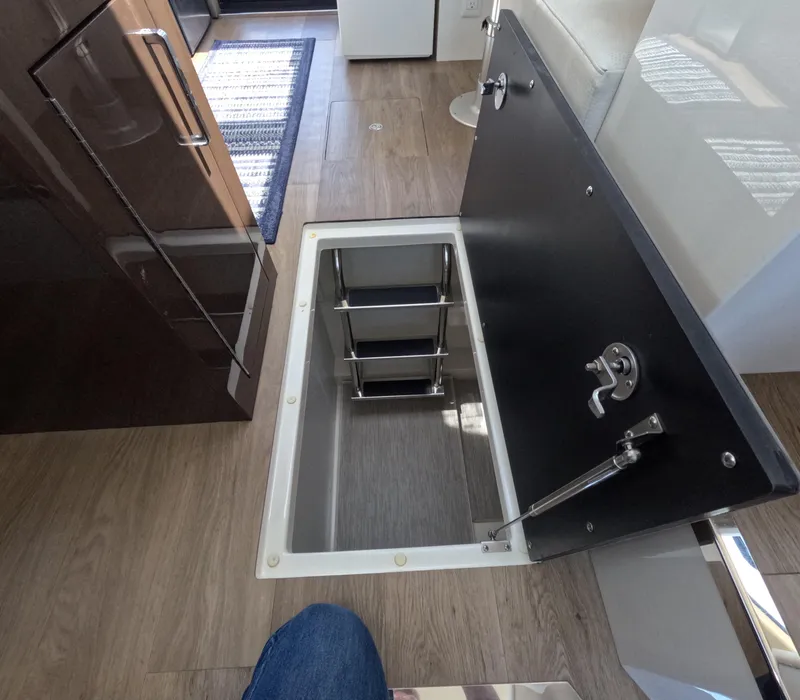 Slide: The Image of Open hatch with ladder in 2019 Carver C37 Coupe interior, featuring wood flooring. - 19