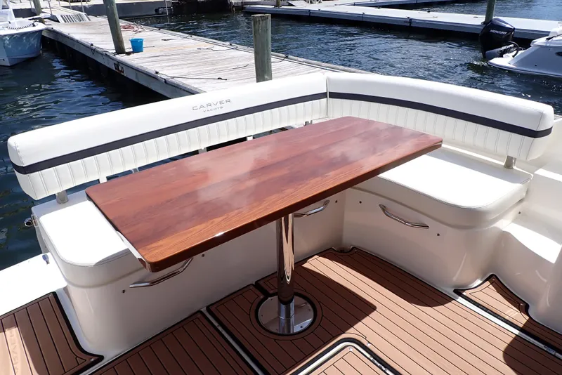 Slide: The Image of 2019 Carver C37 Coupe yacht with elegant wooden table and cushioned seating on deck. - 22