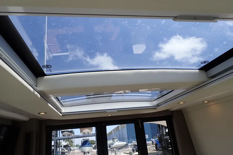 Slide: The Image of Sunroof view from 2019 Carver C37 Coupe, showcasing clear blue sky and clouds. - 29