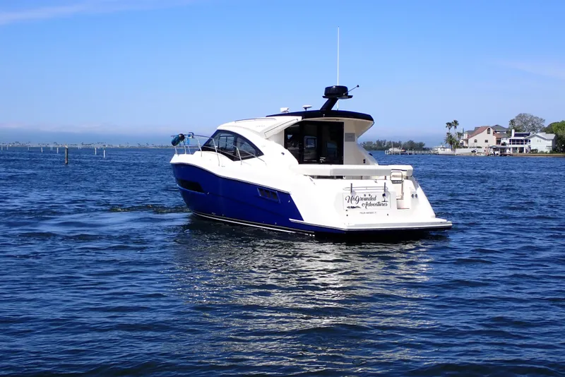 Slide: The Image of 2019 Carver C37 Coupe yacht cruising on a sunny day near coastal homes. - 3