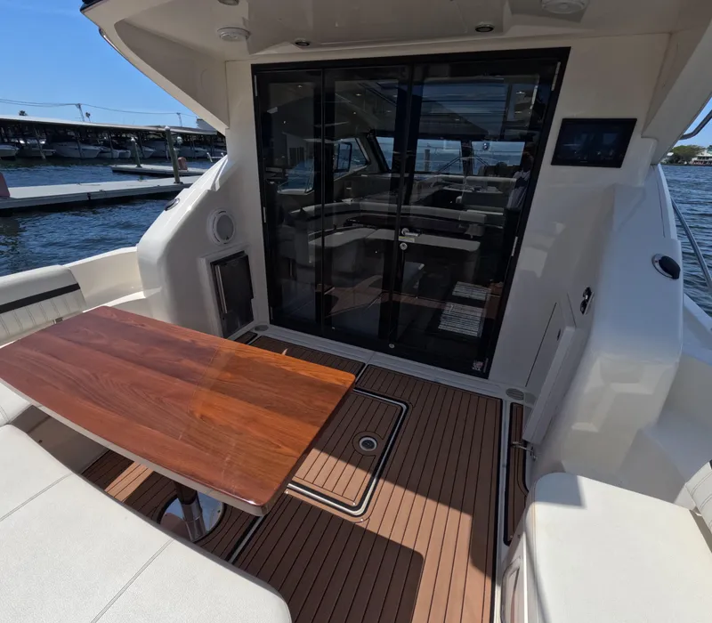 Slide: The Image of 2019 Carver C37 Coupe yacht deck with wooden table and glass doors. - 4