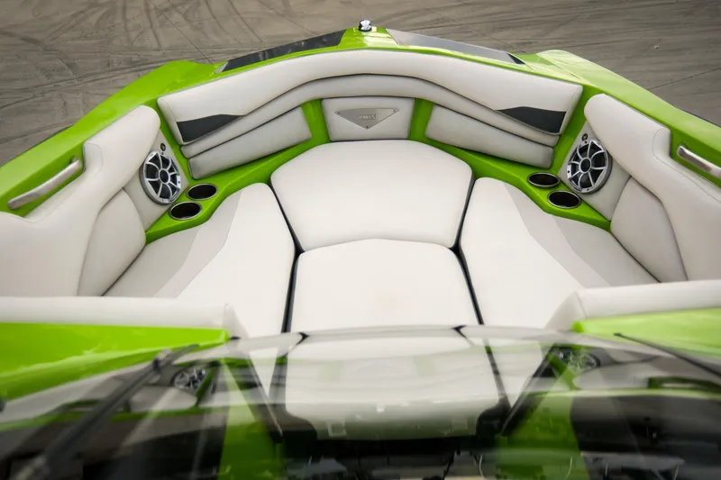 Slide: The Image of 2016 Axis A22 boat interior with green and white seating, cup holders, and speakers. - 11