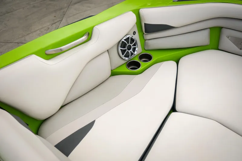 Slide: The Image of 2016 Axis A22 boat interior with white seats, green accents, and cup holders. - 13