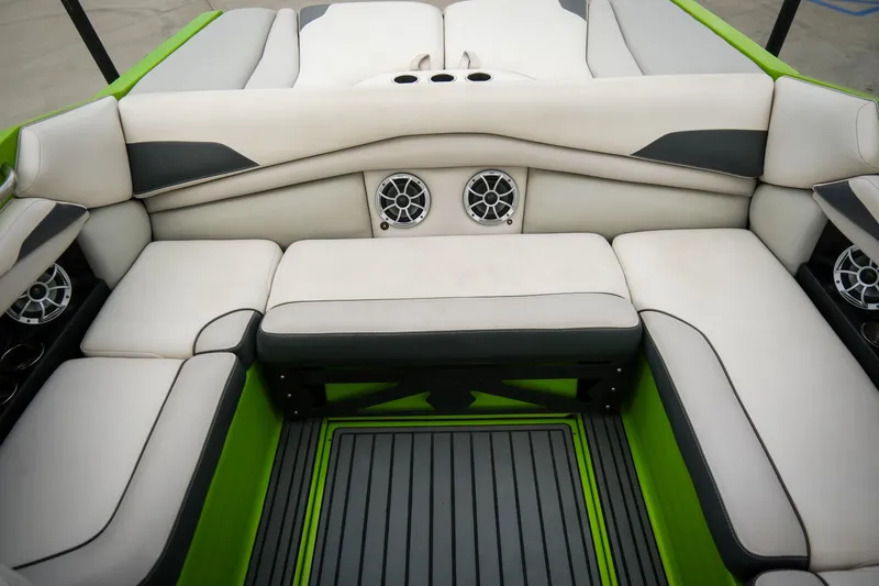 Slide: The Image of 2016 Axis A22 boat interior with white seating, green accents, and built-in speakers. - 16
