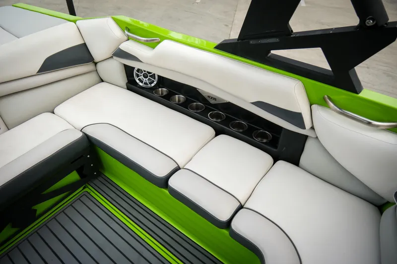 Slide: The Image of 2016 Axis A22 boat interior with white seating, green accents, and cup holders. - 17