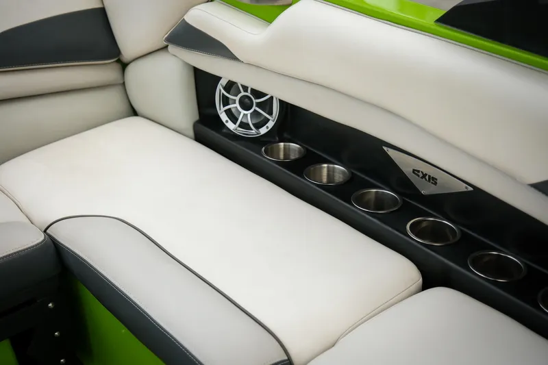 Slide: The Image of 2016 Axis A22 boat interior with white seating, cup holders, and speaker. - 18