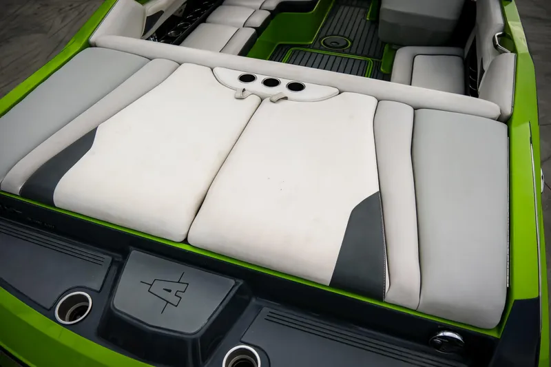Slide: The Image of 2016 Axis A22 boat interior with green and white seating, featuring cup holders. - 6