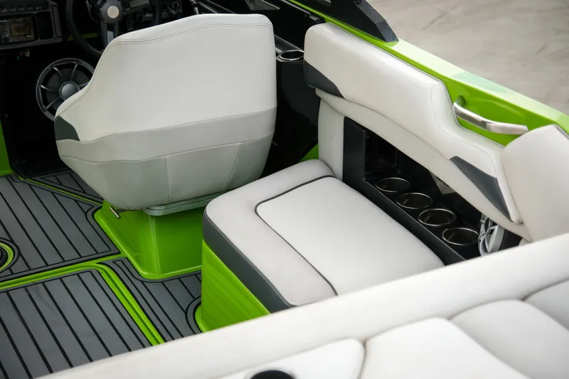 Slide: The Image of 2016 Axis A22 boat interior with green accents and white seating. - 9
