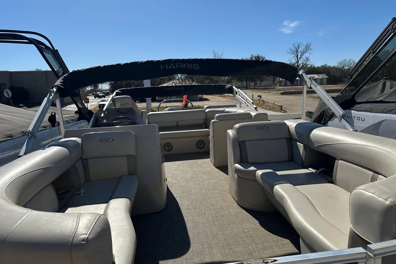 Slide: The Image of 2019 Harris Cruiser 230 pontoon boat with spacious seating and canopy, docked outdoors. - 4