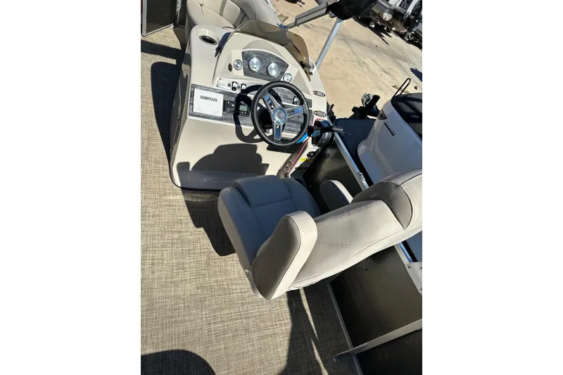 Slide: The Image of 2019 Harris Cruiser 230 boat interior with steering wheel and seating. - 7