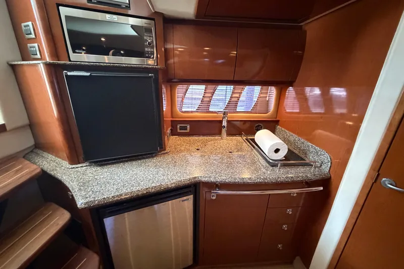 Slide: The Image of 2008 Sea Ray 38 Sundancer galley with microwave, sink, and compact refrigerator. - 22