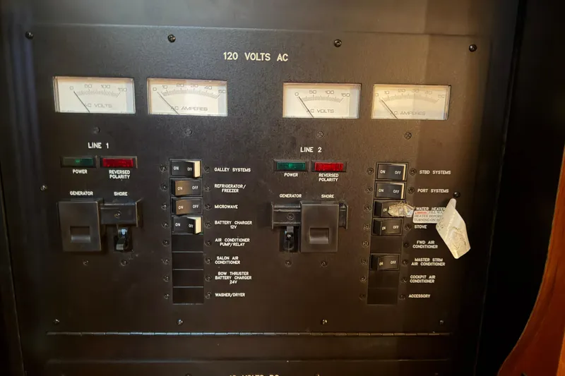 Slide: The Image of Electrical control panel of 2008 Sea Ray 38 Sundancer boat, showing voltage and amperage meters. - 32