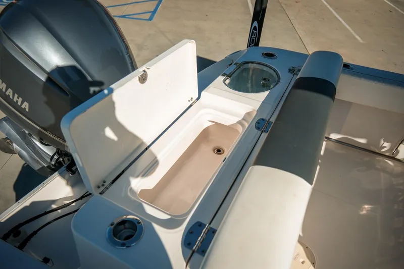 Slide: The Image of 2020 Robalo R242 Center Console boat with Yamaha engine, featuring open storage compartment. - 12