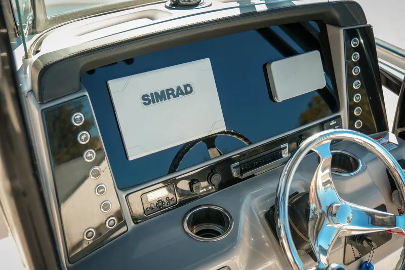 Slide: The Image of 2020 Robalo R242 Center Console dashboard with Simrad display and steering wheel. - 16