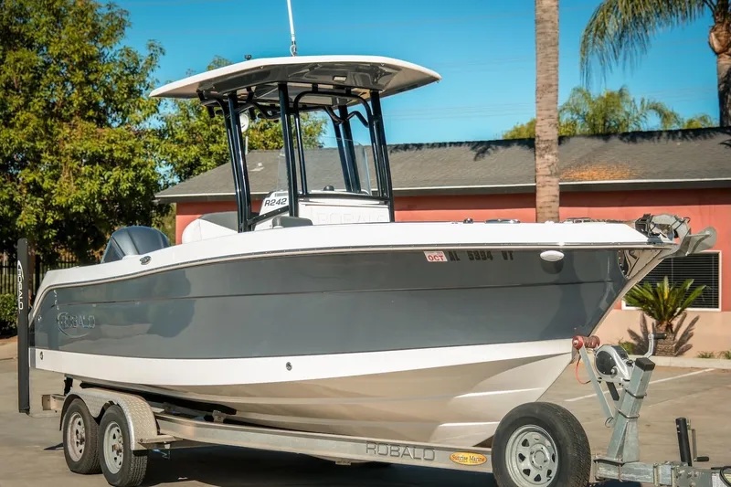 Slide: The Image of 2020 Robalo R242 Center Console boat on trailer, parked outdoors. - 4