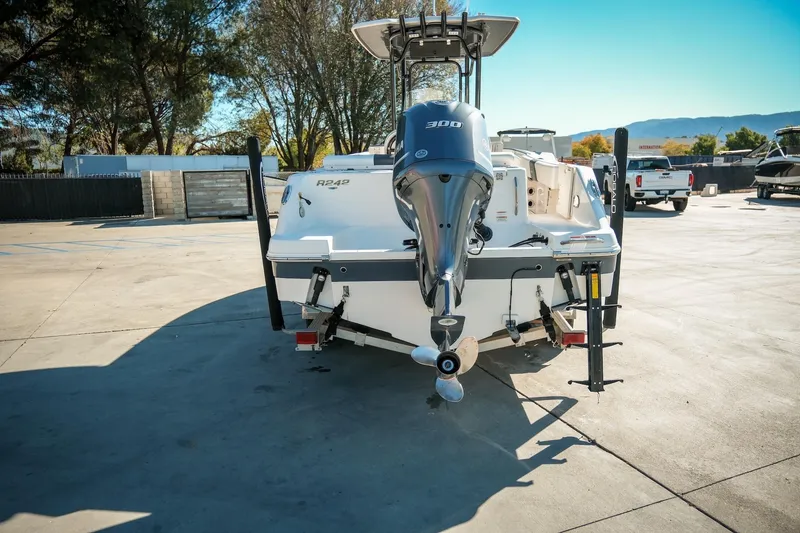 Slide: The Image of 2020 Robalo R242 Center Console boat with powerful outboard motor in a sunny marina. - 9