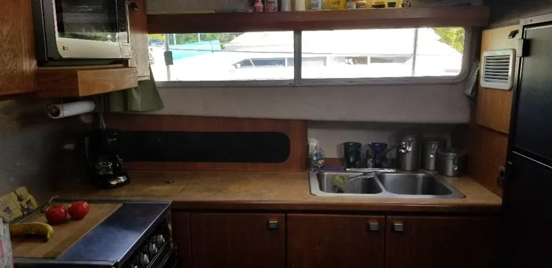 Slide: The Image of 1989 Bayliner 3888 Motoryacht kitchen with sink and stove. - 15