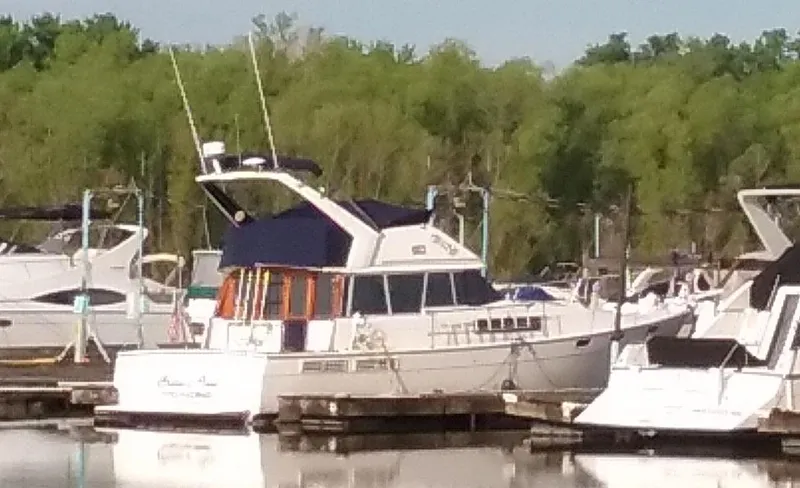 Slide: The Image of 1989 Bayliner 3888 Motoryacht docked, surrounded by other boats. - 26