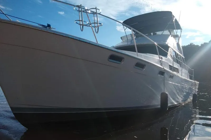 Slide: The Image of 1989 Bayliner 3888 Motoryacht on calm water under a clear blue sky. - 34