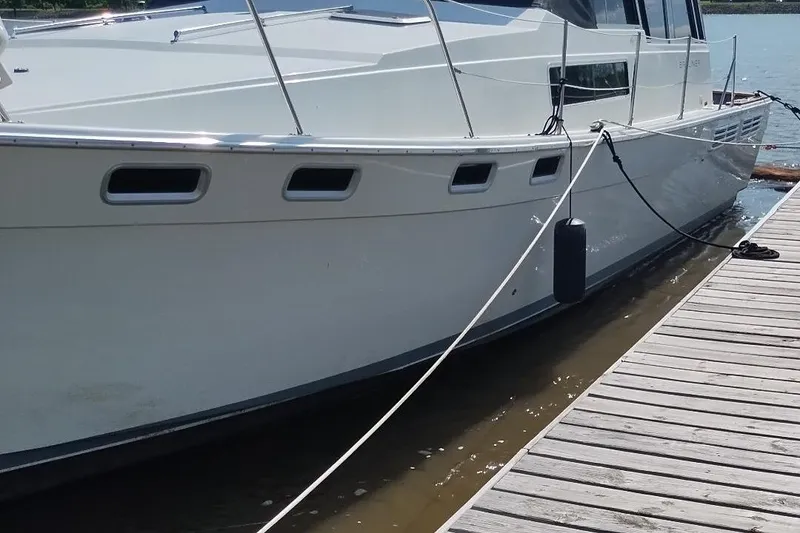 Slide: The Image of 1989 Bayliner 3888 Motoryacht docked at a marina, side view. - 36