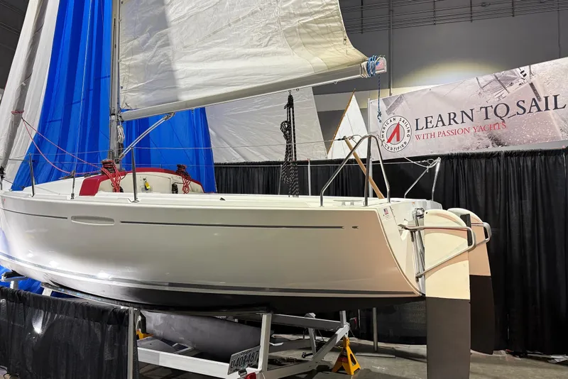 Slide: The Image of 2016 Beneteau First 22 sailboat displayed at a sailing event with "Learn to Sail" banner. - 2