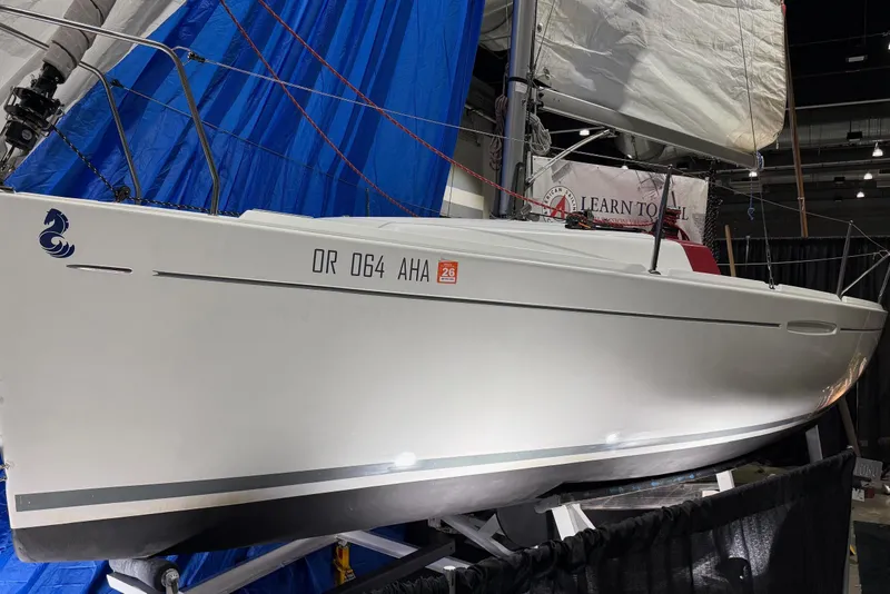 Slide: The Image of 2016 Beneteau First 22 sailboat displayed indoors with blue and white sails. - 6