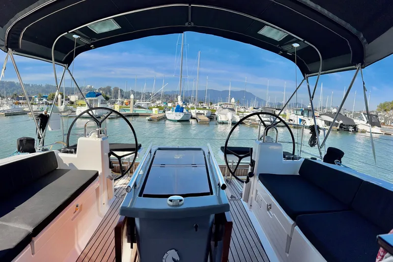 Slide: The Image of 2019 Beneteau Oceanis 41.1 sailboat interior with dual steering wheels in a marina setting. - 24