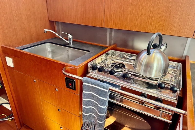 Slide: The Image of 2019 Beneteau Oceanis 41.1 yacht kitchen with sink, stove, and kettle. - 34