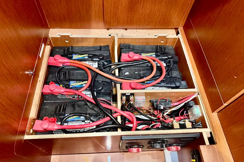 Slide: The Image of Battery compartment of a 2019 Beneteau Oceanis 41.1 sailboat, featuring multiple batteries and wiring. - 64