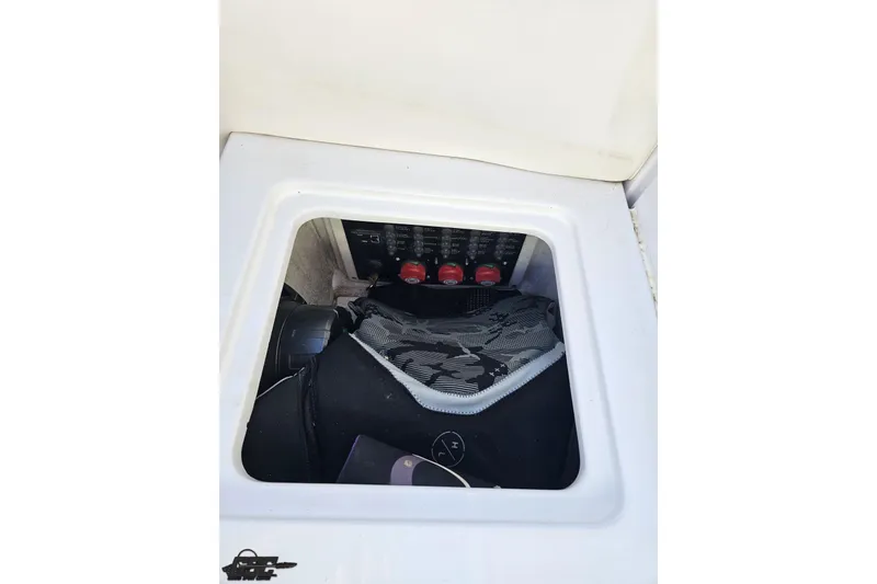 Slide: The Image of Storage compartment in a 2008 Donzi 27 ZR boat, featuring electrical panel and gear. - 101