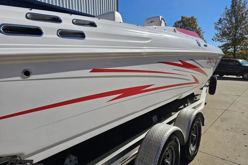 Slide: The Image of 2008 Donzi 27 ZR boat with red graphics on a trailer, parked outdoors. - 12