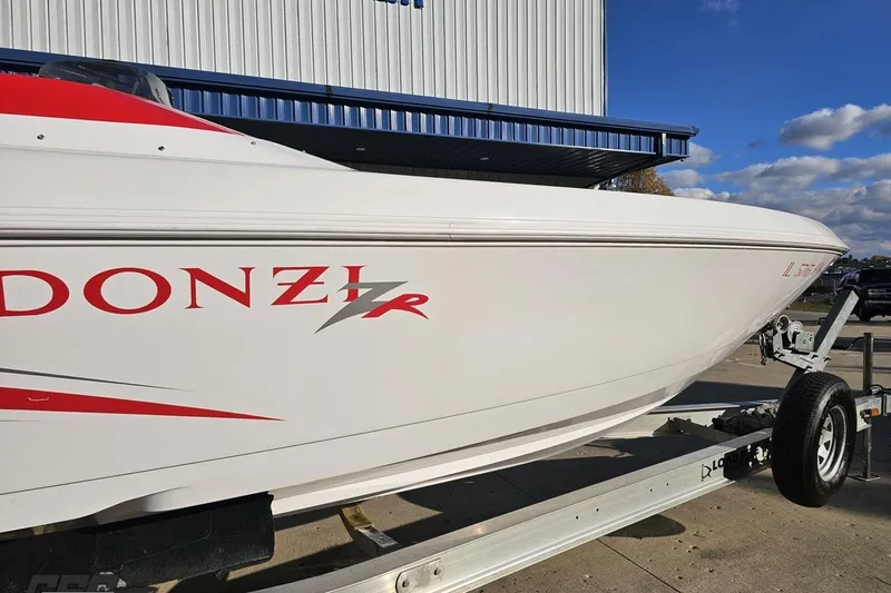 Slide: The Image of 2008 Donzi 27 ZR speedboat on trailer, white with red accents, parked outdoors. - 16