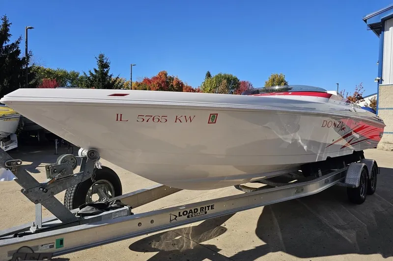 Slide: The Image of 2008 Donzi 27 ZR speedboat on trailer, white with red accents, parked outdoors. - 22