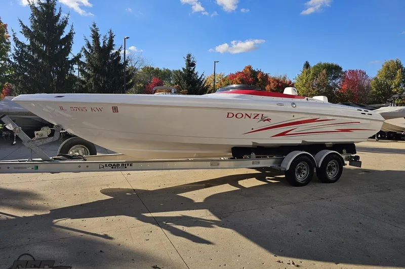 Slide: The Image of 2008 Donzi 27 ZR speedboat on trailer, parked outdoors with trees in the background. - 23
