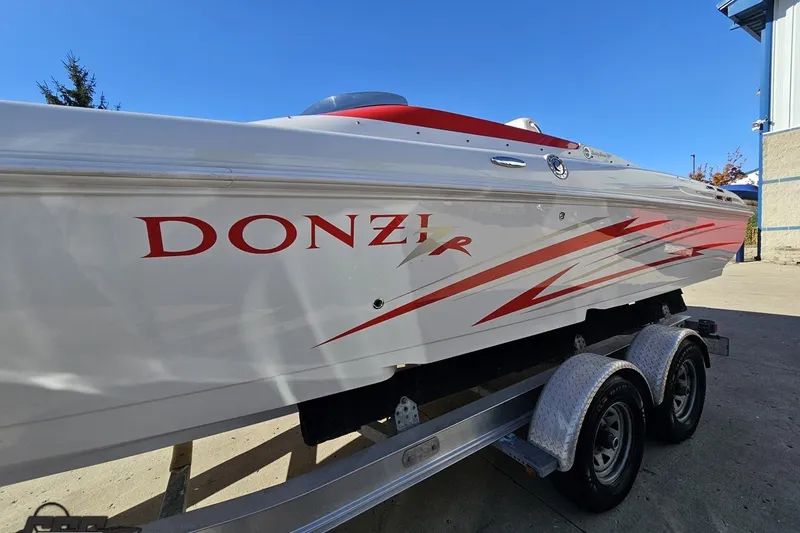 Slide: The Image of 2008 Donzi 27 ZR speedboat on trailer, featuring sleek red and white design. - 26