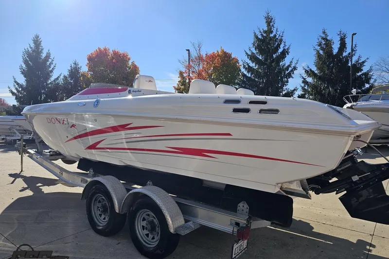 Slide: The Image of 2008 Donzi 27 ZR speedboat with red accents on a trailer, outdoors. - 32