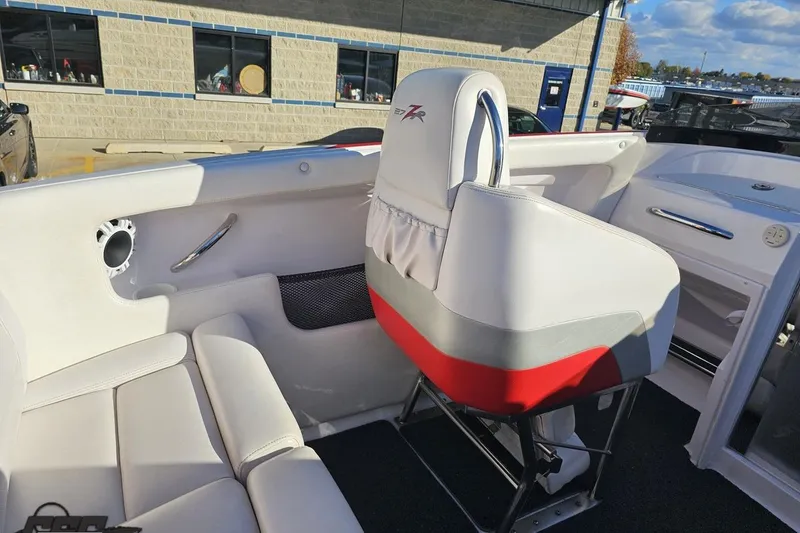 Slide: The Image of 2008 Donzi 27 ZR boat interior with white and red seating, docked outdoors. - 56