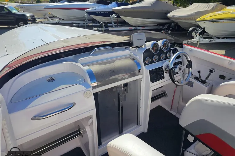Slide: The Image of 2008 Donzi 27 ZR boat interior with steering wheel, gauges, and seating in a marina setting. - 61