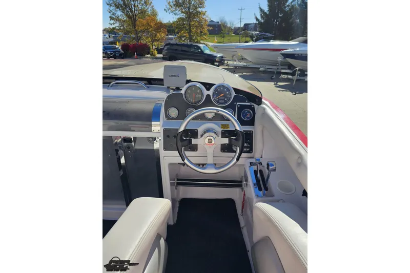 Slide: The Image of 2008 Donzi 27 ZR boat cockpit with steering wheel and gauges, parked outdoors. - 63