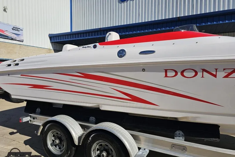 Slide: The Image of 2008 Donzi 27 ZR speedboat with red graphics on a trailer, parked outside a building. - 8