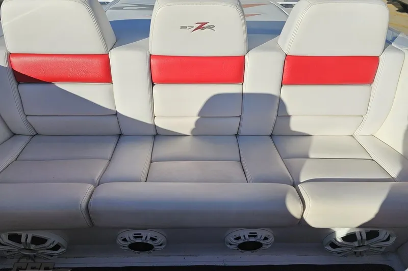 Slide: The Image of 2008 Donzi 27 ZR boat interior with white and red seating, featuring speaker system. - 94