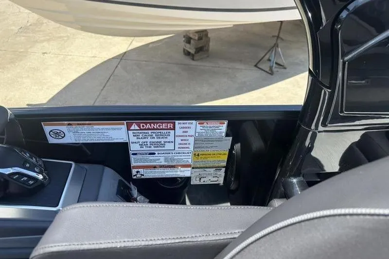 Slide: The Image of 2026 Bennington 30 QSBAX boat interior with safety warning labels and controls. - 10