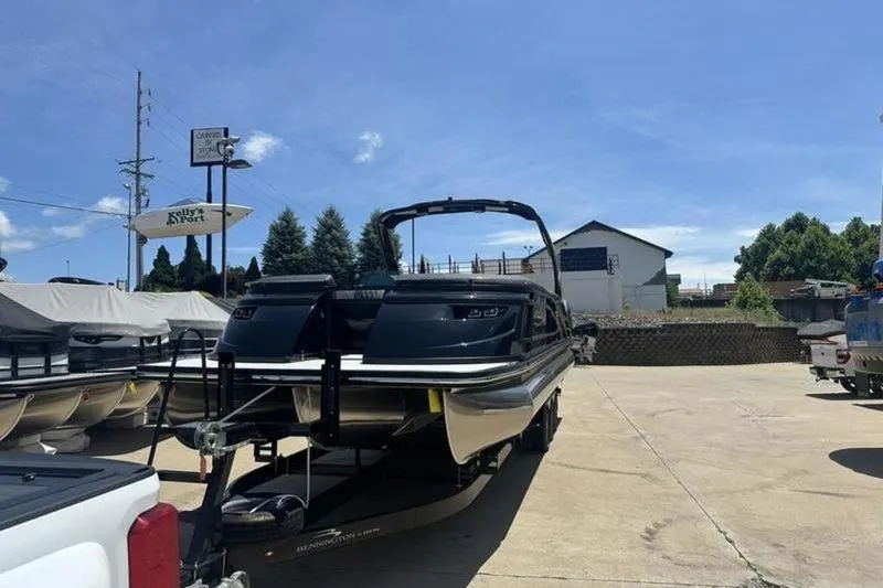 Slide: The Image of 2026 Bennington 30 QSBAX pontoon boat on trailer in sunny outdoor setting. - 17