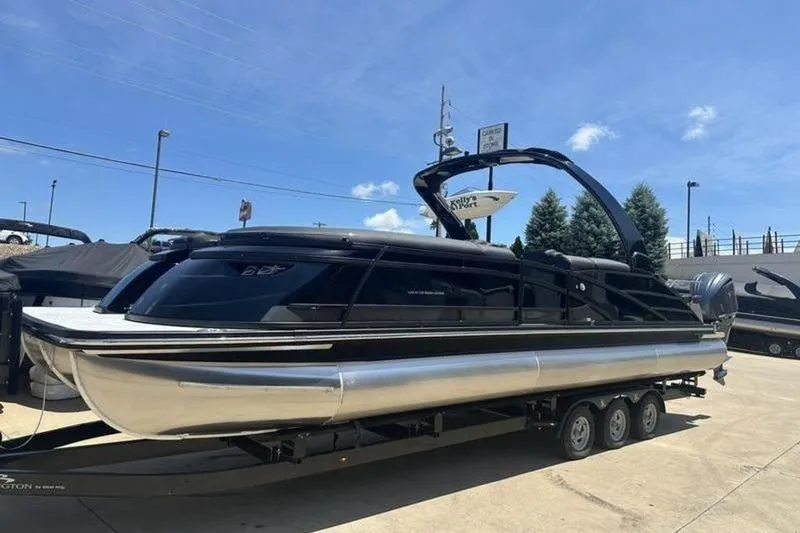 Slide: The Image of 2026 Bennington 30 QSBAX pontoon boat on trailer under clear blue sky. - 18