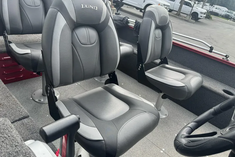 Slide: The Image of 2021 Lund 1650 Angler SS boat interior with gray seating and steering wheel. - 11
